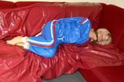 Pia tied and gagged by Sophie on the sofa wearing a shiny blue PVC sauna suit (Pics)