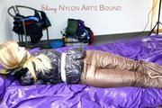 Samantha tied and gagged on bed wearing shiny downpants in brown and a black downjacket (Pics)