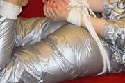 Sophie tied and gagged on the sofa wearing a shiny silver PVC sauna suit (Pics)