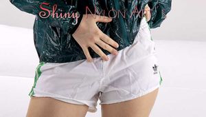 Watching our sexy archive girl wearing a sexy white shiny nylon shorts and a green rainjacket (Pics)