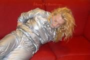 Sophie tied and gagged on the sofa wearing a shiny silver PVC sauna suit (Pics)