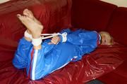 Pia tied and gagged by Sophie on the sofa wearing a shiny blue PVC sauna suit (Pics)