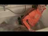 Watching sexy Katharina wearing a sexy black shiny nylon shorts and an orange downjacket enjoying her foambath (video)