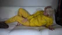 Watching Pia preparing her sofa with a shiny nylon cloth wearing a yellow shiny nylon rainsuit enjoying herslef on the sofa (Video)