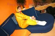 Archive girl tied and gagged on sofa wearing a shiny yellow rainwear (Pics)