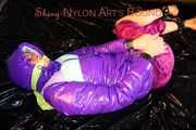 Pia wearing a pink rain pants and a purple down jacket tied with cuffs and gagged on bed (Pics) 