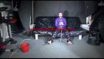 Sandra tied and gagged on a sofa wearing a shiny nylon down jacket and a rain pants (Video)