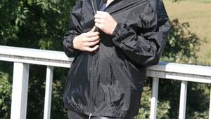 Leonie posing outdoor on a bridge wearing a sexy black shiny nylon rainwear combination (Pics)