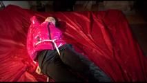 Mara tied, gagged and hooded on a bed wearing a supersexy black rain pants and a pink down jacket (Video)