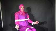 Sexy Pia tied and gagged with ropes and a clothgag on a hairdresser´s chair wearing a sexy pink shiny nylon downsuit (Video)