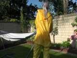 Watch Chloe enjoying the warm Sun in her yellow shiny nylon Rainsuit 