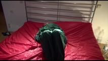 Lucy tied and gagged on a bed with red shiny nylon cloth wearing supersexy green rainwear (Video)