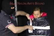 Watching sexy Sandra wearing a sexy pink shiny nylon rain pants and a shiny nylon pink down jacket being tucked in a down cover and tie and gagged and hooded with tape and a ballgag (Pics)