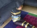 A video with one of our archive girls tied and gagged in shiny nylon rainwear