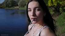 Beautiful girl from Russia smoking two cigarettes outside