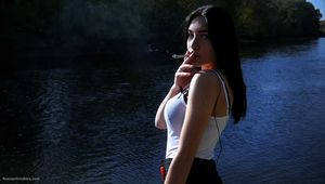 Beautiful girl from Russia smoking two cigarettes outside