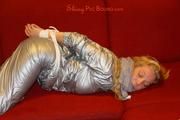 Sophie tied and gagged on the sofa wearing a shiny silver PVC sauna suit (Pics)