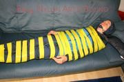 Katharina tied and gagged with tape on a sofa wearing shiny rainwear (Pics)