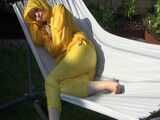 Watch Chloe enjoying the warm Sun in her yellow shiny nylon Rainsuit 