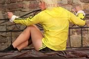 Pia tied and gagged on a princess bed wearing a sexy shiny black shorts and a yellow rain jacket (Pics)