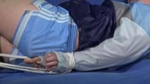 Jill tied and gagged on a blue sofa wearing a sexy lightblue shiny nylon shorts and an oldschool rainjacket (Video)
