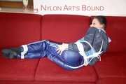 Lucy wearing a blue shiny nylon pants and an oldschool blue rain jacket tied and gagged with ropes on a sofa (Pics)