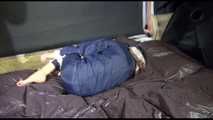 Sexy Sandra wearing a sexy blue shiny nylon pants and a sexy blue rain jacket tied and gagged with ropes and a cloth gag on a bed (Video)