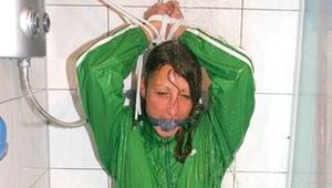 Stella tied and gagged in a shower wearing a white shiny nylon shorts and a green rain jacket (Pics)