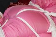 Lucy tied and gagged on a sofa wearing a pink shiny nylon skibib (Pics)
