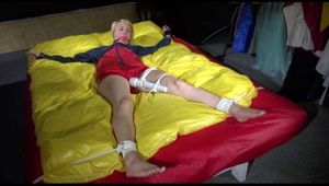 SEXY SONJA being tied and gagged on a bed stimulated with an massager wearing a hot red shiny nylon shorts and an oldschool red/blue rain jacket (Video)