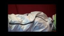 Pia tied and gagged on a sofa wearing a shiny white rainsuit (Video)