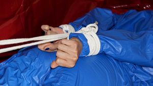 Pia tied and gagged by Sophie on the sofa wearing a shiny blue PVC sauna suit (Pics)