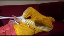 Lucy tied, gagged and hooded on a red sofa wearing a sexy orange shiny nylon pants and a yellow rain jacket (Video)