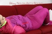 Jill tied and gagged on a red sofa wearing a sexy pink down combination (Pics)