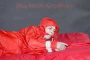 Destiny wearing a sexy red rain suit tied and gagged and hooded with ropes and a cloth gag on a bed (Pics)