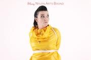 Jill tied and gagged in a shiny yellow rainsuit and rubber boots