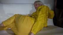 Watching Pia preparing her sofa with a shiny nylon cloth wearing a yellow shiny nylon rainsuit enjoying herslef on the sofa (Video)