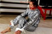 Alina tied and gagged in a shiny silver PVC saunasuit