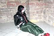 Jill tied, gagged and hooded on a cellar floor wearing a shiny green rain pants and a shiny black down jacket (Pics)