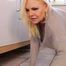 Mature Cara cleans the floor in a grey sweater and pantyhose