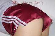 Sexy Sandra wearing a very shiny bordeaux red shiny nylon shorts and a grey top posing for you on a sofa (Pics)