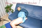 Jill tied, gagged and hooded on a sofa wearing sexy shiny nylon shorts and a rain jacket (Pics)