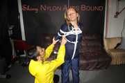 Sandra tied by Stella both wearing shiny nylon rainwear