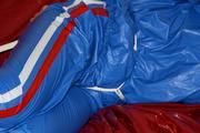 Pia tied and gagged by Sophie on the sofa wearing a shiny blue PVC sauna suit (Pics)