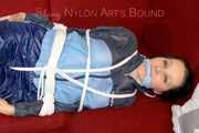 Lucy wearing a blue shiny nylon pants and an oldschool blue rain jacket tied and gagged with ropes on a sofa (Pics)