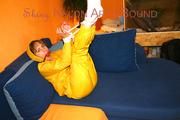 Archive girl tied and gagged on sofa wearing a shiny yellow rainwear (Pics)