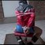 Mara tied and gagged on a bar stool in an old cellar wearing a sexy lightblue shijny nylon shorts and a red rain jacket (Video)