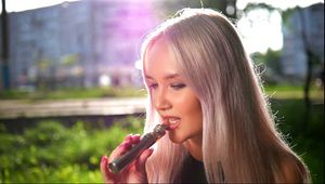 Blonde girl Natalia is vaping on the street