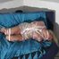 Beautiful archive girl tied and gagged on bed wearing an white transparent PVC suit (Video)