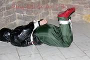 Jill tied, gagged and hooded on a cellar floor wearing a shiny green rain pants and a shiny black down jacket (Pics)